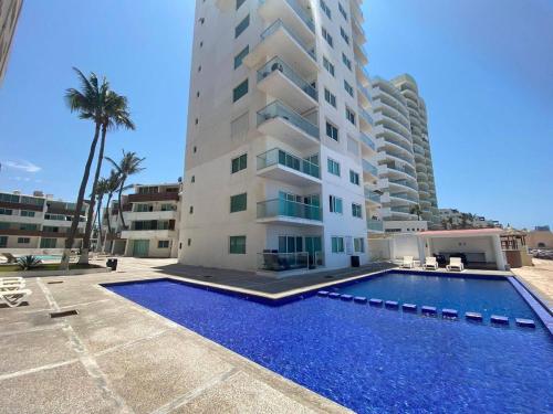 a building with a swimming pool in front of a building at Marina del Sol Resort - beautiful 2 bdrm Sleeps 8 -Ocean front in Mazatlán