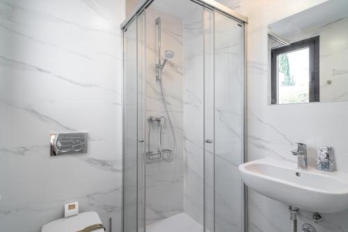 uma casa de banho branca com um chuveiro e um lavatório. em Terrazas de Ladera Duplex 10 Casasol em Nerja