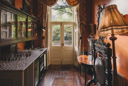 um quarto com uma porta, uma mesa e uma janela em Ballyvolane House em Fermoy