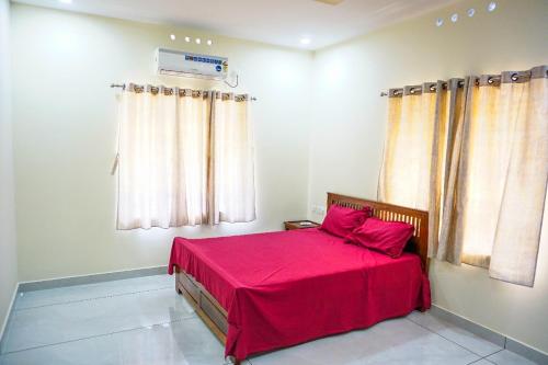 um quarto com uma cama com um cobertor vermelho em PEACEFUL LIVING SUITE II em Cochin