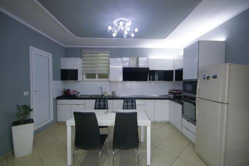 uma cozinha com uma mesa e cadeiras e um frigorífico em Central 2BD Villa em Tirana