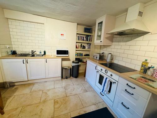 a kitchen with white cabinets and white appliances at Apartment near Harbourside & city centre in Bristol
