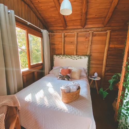 a bedroom with a bed in a wooden cabin at Itapeva Ecovillage in Torres