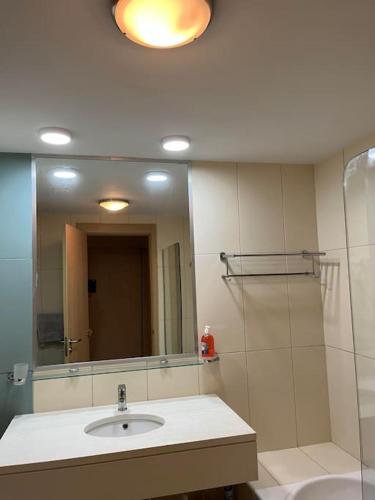a bathroom with a sink and a shower and a mirror at Holiday Home - Santa Maria in Prainha
