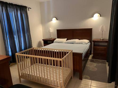 a bedroom with a bed and a crib in it at Holiday Home - Santa Maria in Prainha