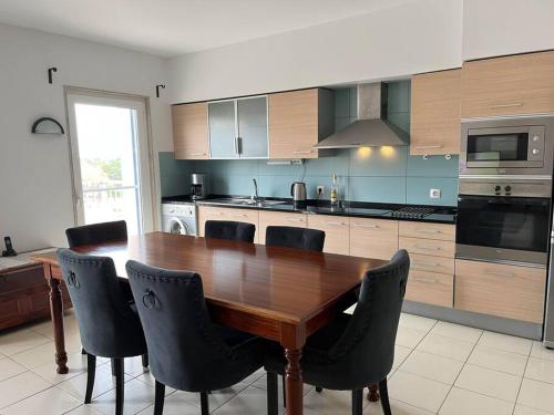 a large kitchen with a wooden table and chairs at Holiday Home - Santa Maria in Prainha