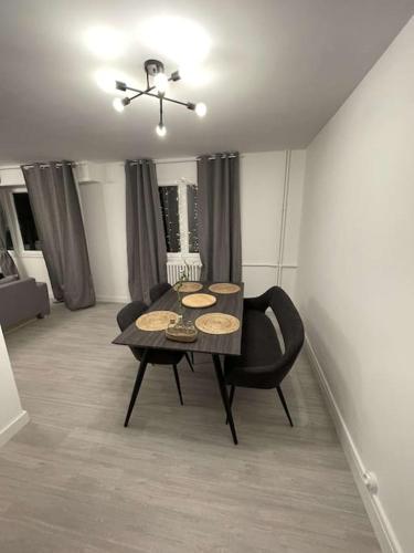 uma sala de jantar com uma mesa e uma cadeira em Superbe appartement avec emplacement idéal em Mulhouse