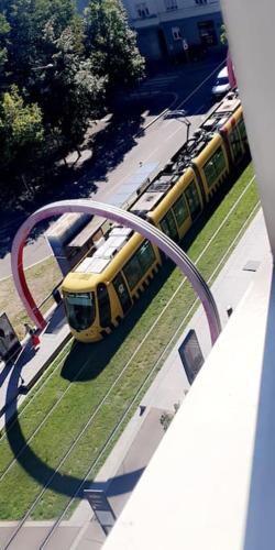 uma vista superior de um comboio amarelo numa rua em Superbe appartement avec emplacement idéal em Mulhouse