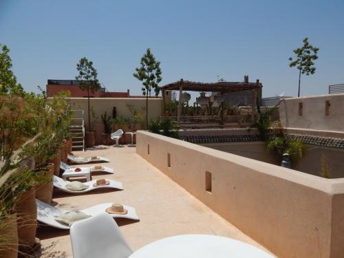 a patio with chairs and tables on a building at Riad De Vinci & SPA in Marrakech