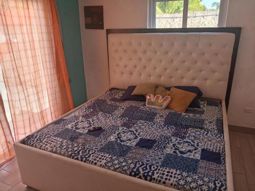 a bed with a quilt and a crown on it at Chalet san marino in Colonia La Providencia