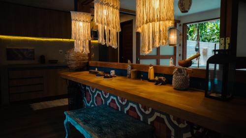 a counter in a room with a mirror and chandeliers at Chalé Pipa Atlântico in Pipa