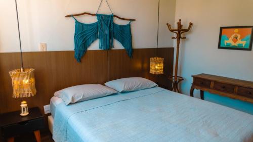 a bedroom with a bed with a blue comforter at Chalé Pipa Atlântico in Pipa