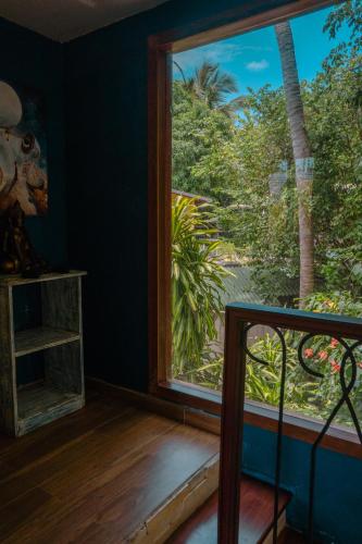 a room with a large window looking out at the jungle at Chalé Pipa Atlântico in Pipa