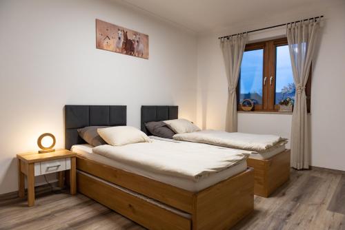 um quarto com 2 camas e uma janela em Apartament Nad Stajnią em Krośnica