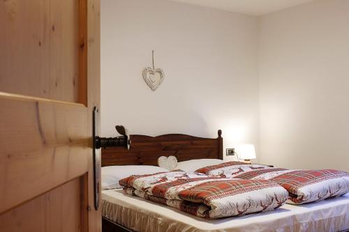 Un dormitorio con una cama con cabecero de madera. en CASA DOLOMIA - Agenzia Dolomiti Affitti, en Cavalese
