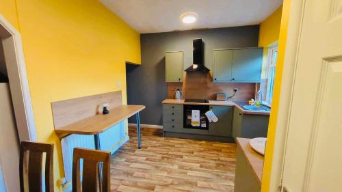 cocina con encimera y paredes amarillas y azules en The Smart Stay - sleeps 5 Wigan central location, en Wigan