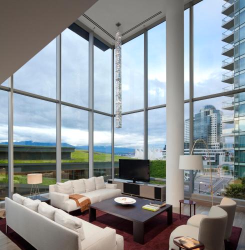 a living room with white furniture and large windows at Fairmont Pacific Rim in Vancouver