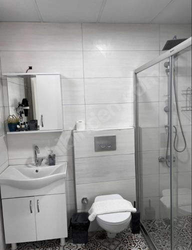 uma casa de banho com um chuveiro, um WC e um lavatório. em GDL DOKUZ OTEL em Kalkanlı