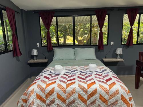 ein Schlafzimmer mit einem Bett mit einer Decke darauf in der Unterkunft El mangal B&B in Suchitoto