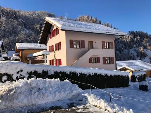 a house covered in snow next to a fence at Perfect Mountain Condo - 4 Valleys - Swiss Alps in Beuson