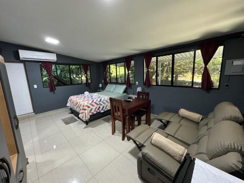 ein Wohnzimmer mit einem Sofa und einem Bett in der Unterkunft El mangal B&B in Suchitoto
