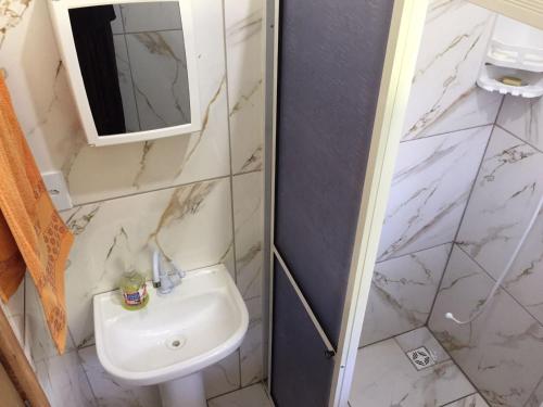 La salle de bains est pourvue d'un lavabo et d'un miroir. dans l'établissement Pousada GaiaPiá, à Morretes