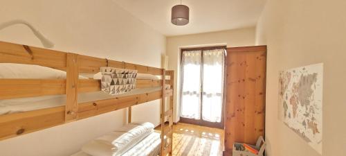 Habitación con literas y ventana. en L'Abete - Introbio Apartment, en Introbio