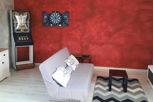 een woonkamer met een stoel en een dartbord bij charmante maison de ville in Saint-Dizier