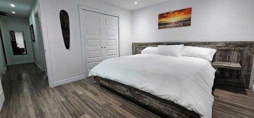 una camera con un letto bianco e una porta in legno di S'évader en montagne a Sainte Brigitte de Laval