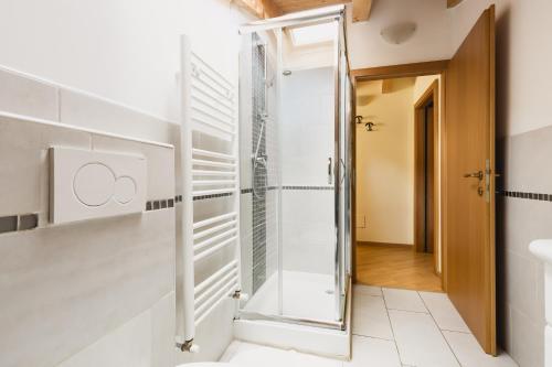 baño con ducha y puerta de cristal en Bergreen Apartments, en Ossana