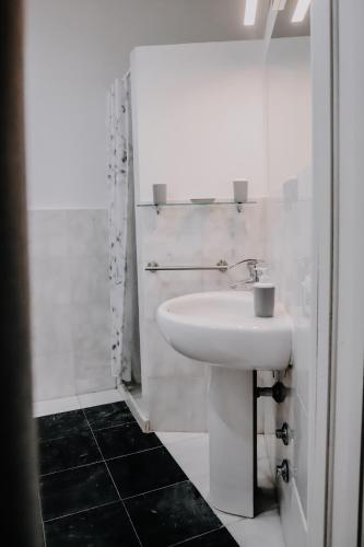 a white bathroom with a sink and a shower at Luminoso Appartamento in Centro - Privitera in Grammichele