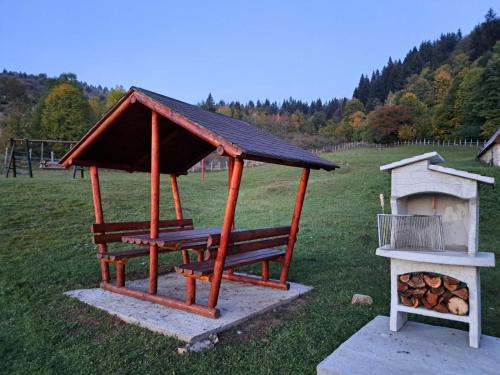 a gazebo with a wood stove in a field at Vikendica i odmaraliste JuliE, Sarajevo-Jahorina in Tvrdimići