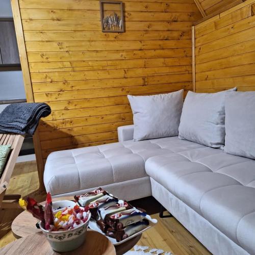 a living room with a couch and a table at Vikendica i odmaraliste JuliE, Sarajevo-Jahorina in Tvrdimići