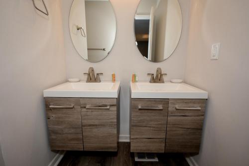 uma casa de banho com dois lavatórios e dois espelhos em Escape to Serenity Luxurious 4Bedroom 3Bath Oasis with Private Pool Near Fort Jackson em Columbia