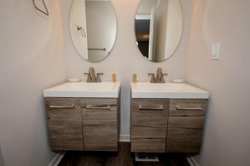 a bathroom with two sinks and two mirrors at 4Bedroom 3Bath Home Near Fort Jackson in Columbia