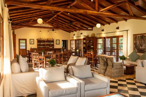 a living room with couches and a table and chairs at Estancia Iberá in Colonia Carlos Pellegrini