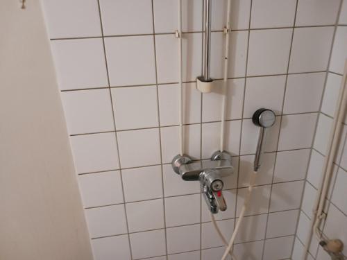 um chuveiro na casa de banho com azulejos brancos em Apartment Reki em Rovaniemi