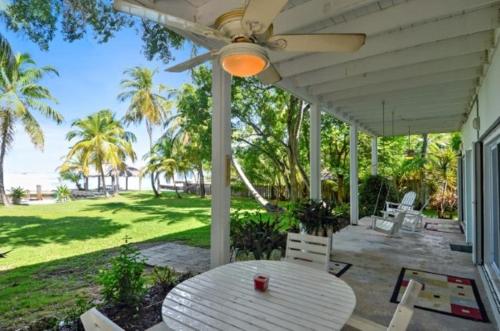 a patio with a table and a ceiling fan at Little Bay Prime in Islamorada