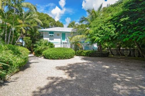 a house with palm trees and a gravel driveway at Little Bay Prime in Islamorada
