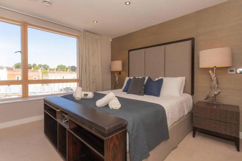 a bedroom with a large bed and a large window at Stylish Penthouse Apartment With Hot Tub in Bath