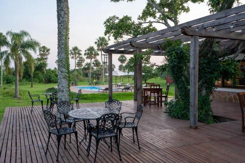 een houten terras met een tafel en stoelen erop bij Estancia Iberá in Colonia Carlos Pellegrini