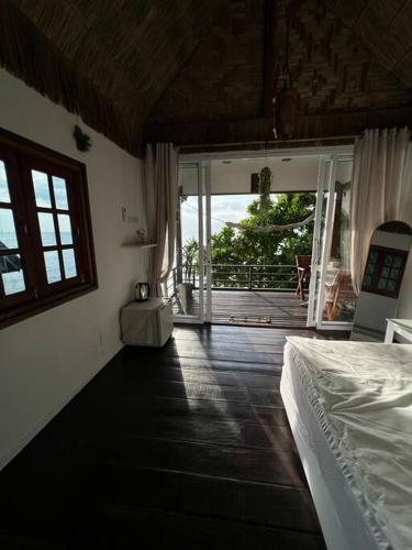 a bedroom with a bed and a view of a deck at Sea Lulaby in Koh Phangan