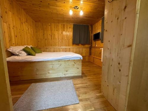 ein Schlafzimmer mit einem Bett in einer Holzhütte in der Unterkunft Vila Piramida in Sighetu Marmaţiei