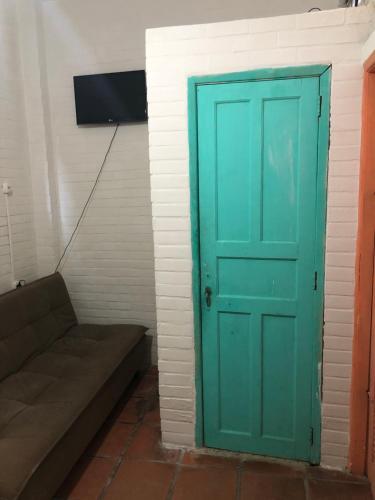a green door in a room with a couch at Hostel dos Reis in Angra dos Reis