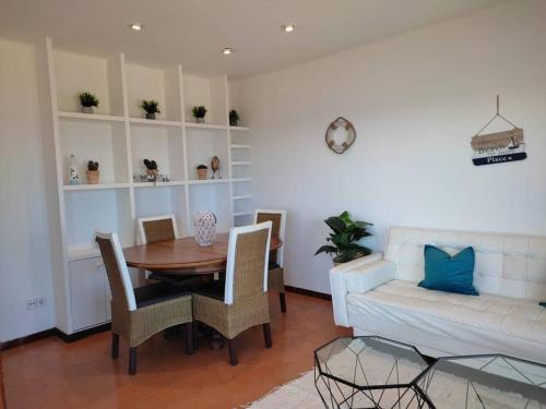 - un salon avec une table et un canapé dans l'établissement Apartamento Primera Linea Playa, à Roda de Bará