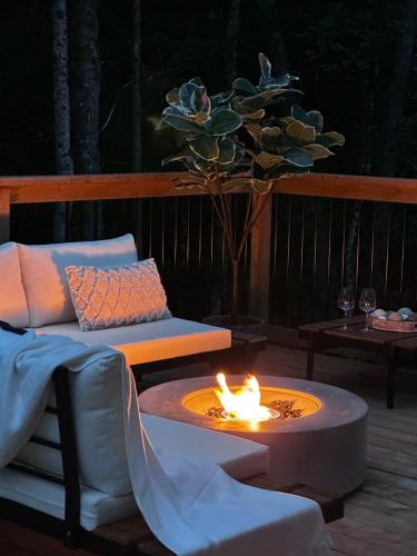 a fire pit on a deck with a couch and a table at Andas cabin CITQ#313550 in Lac-Superieur