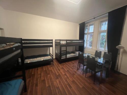 a room with two bunk beds and a table and chairs at Hostel Moon in Prague