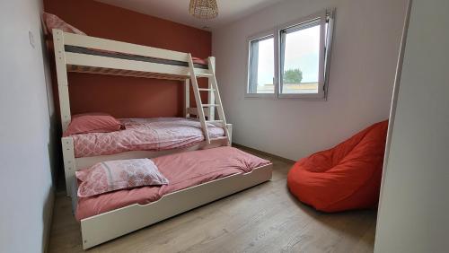 a bedroom with two bunk beds and a window at Villa Lou Sanaé - Bord de mer - Spa, paddle, Kayak - Classé 4 étoiles in Santec