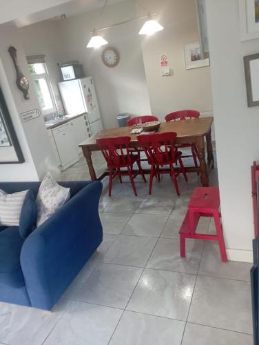 a living room with a table and red chairs at Lakeside house in Oughterard