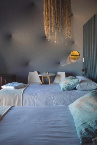 2 Betten in einem Zimmer mit einem Tisch dazwischen in der Unterkunft Domos Park in Mar de las Pampas